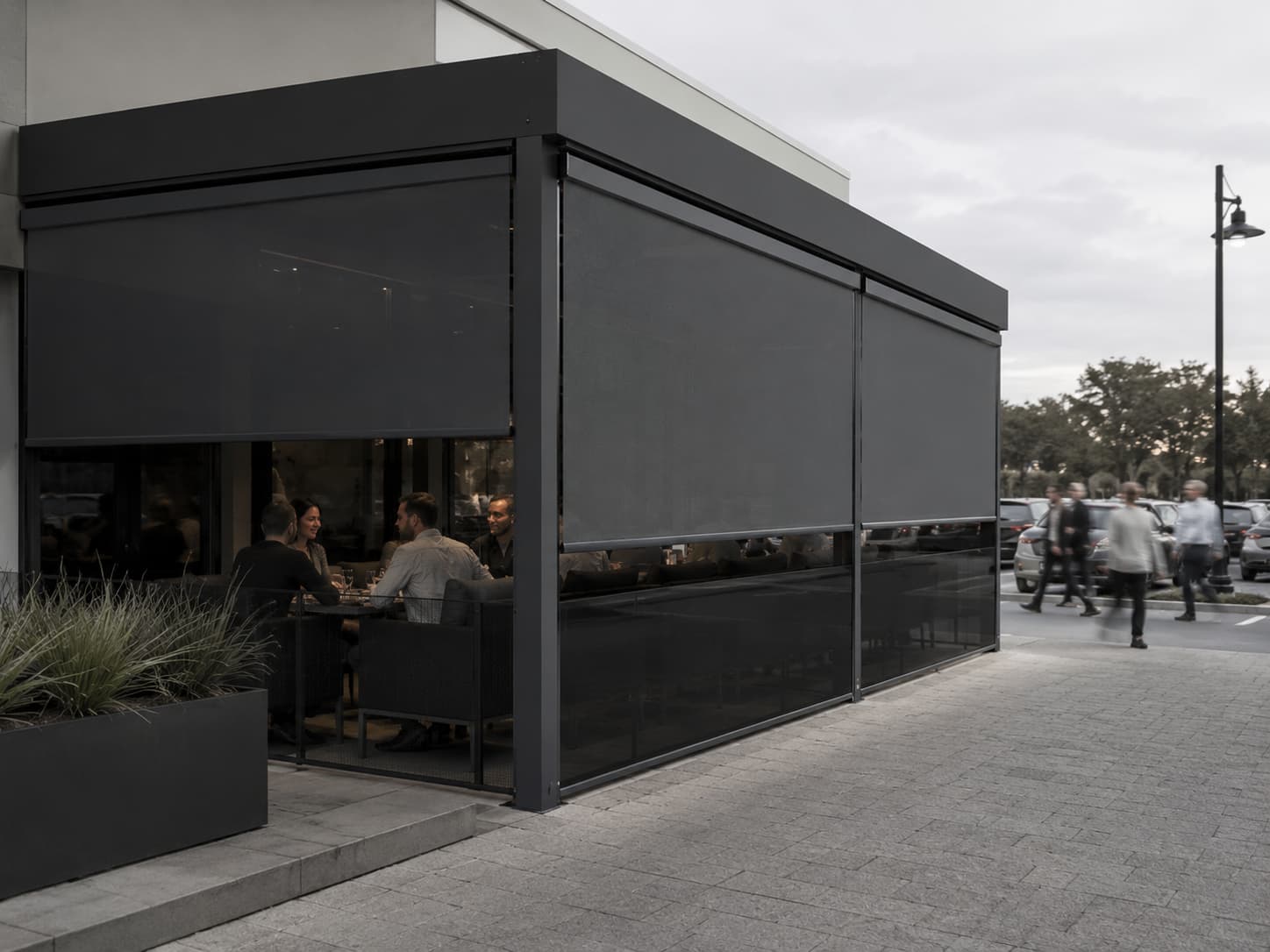 Commercial hospitality terrace enclosed by multiple dark mesh Velaris outdoor blinds
