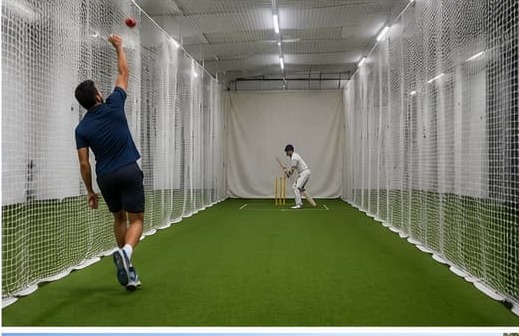Indoor cricket practice lane with white side and roof netting