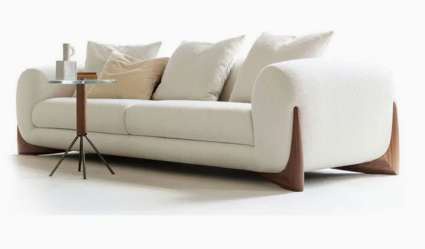 Cream Nordic sofa with sculpted timber side supports and loose cushions