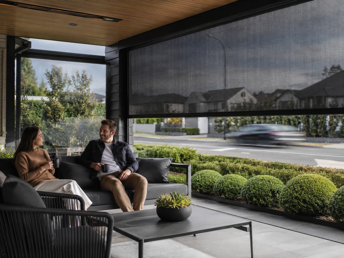 Restaurant terrace with coordinated dark outdoor blinds on adjacent sides