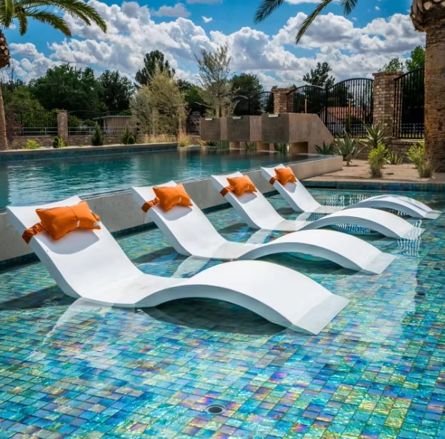 Mosaic shallow-water shelf with multiple sculpted in-pool loungers