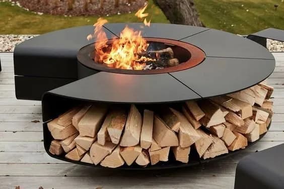 Huoshen circular fire pit with broad table surface, central wood fire and integrated firewood storage