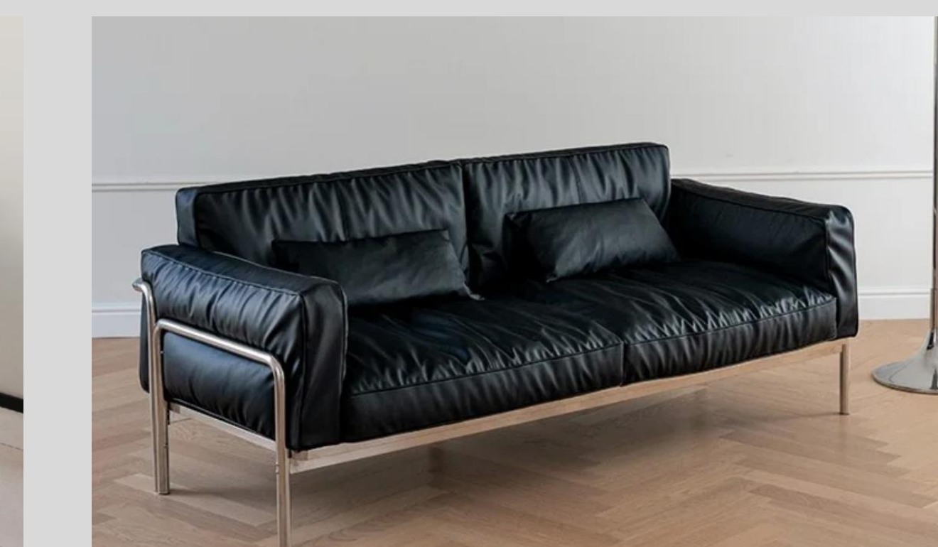 Black leather sofa held within a slim exposed tubular metal frame