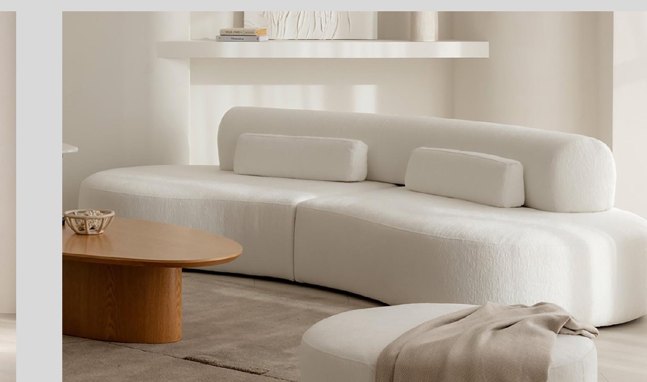 Long cream curved sofa with rounded back and low sculptural seat