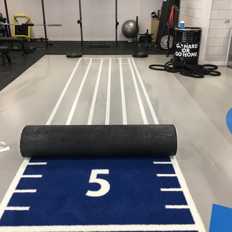 Performance training lane with roll-format surface being installed
