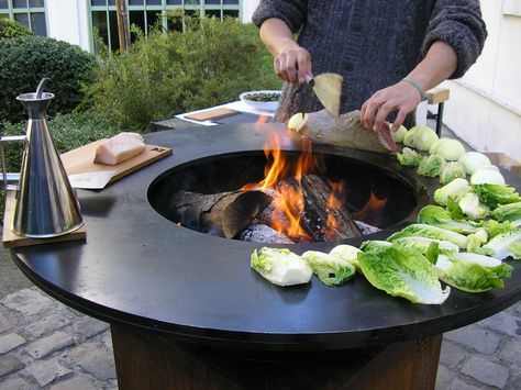 Chef cooking around a FJARVIK circular live-fire plancha