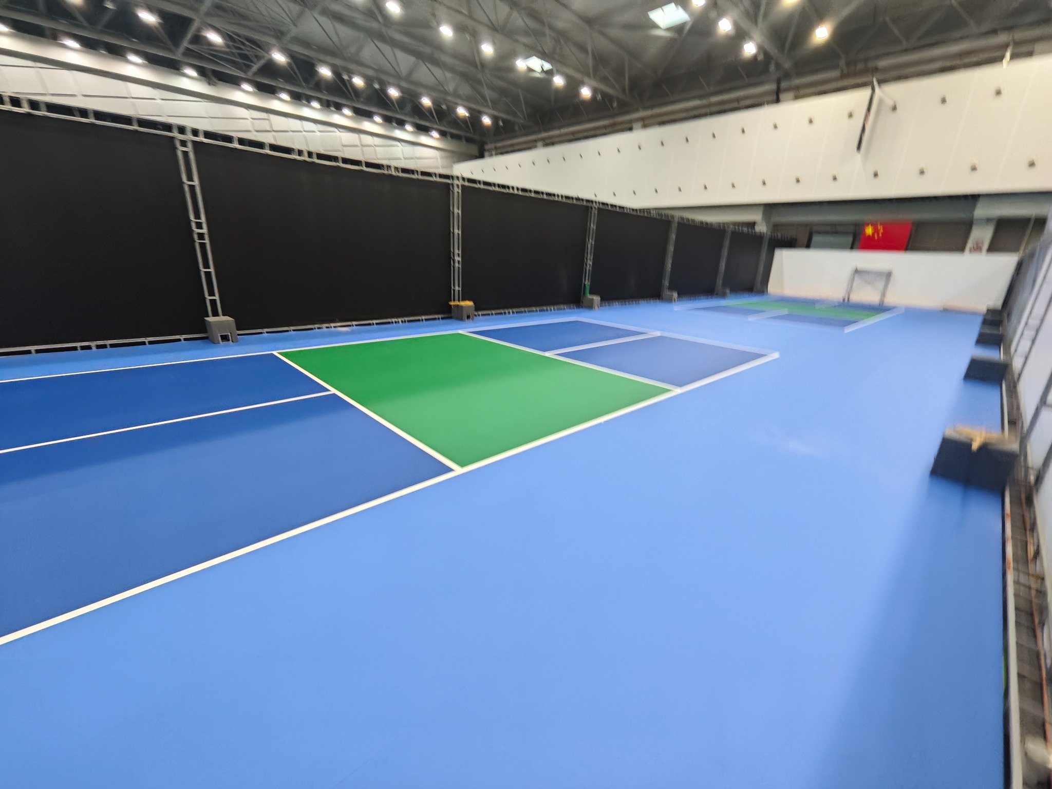 Blue and green indoor pickleball courts installed for an event