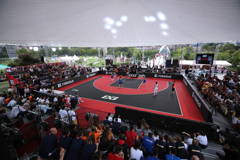 Red and black FIBA 3x3 competition court with crowd seating