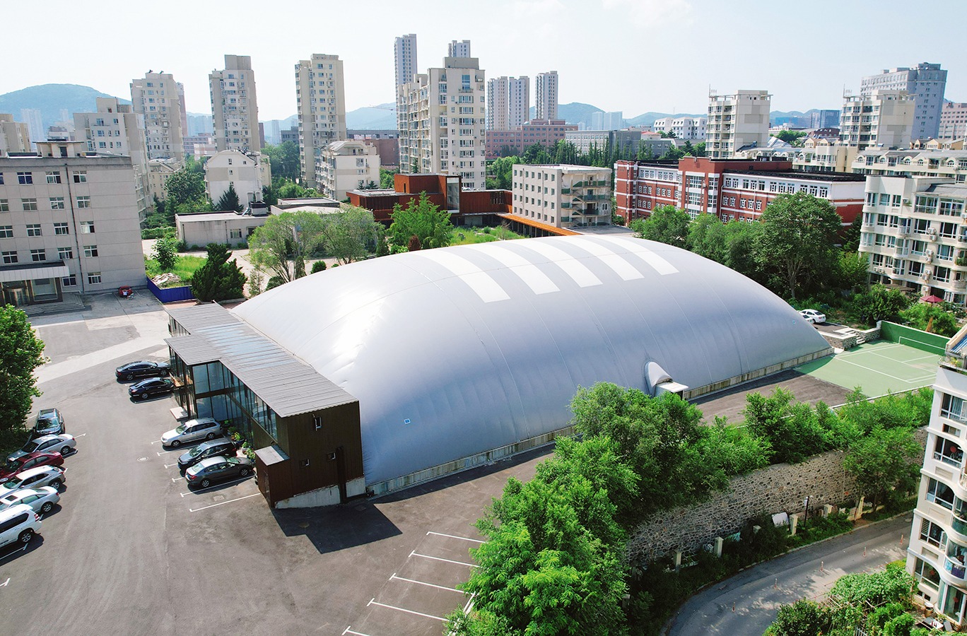 White air-supported sports dome in a dense urban neighbourhood