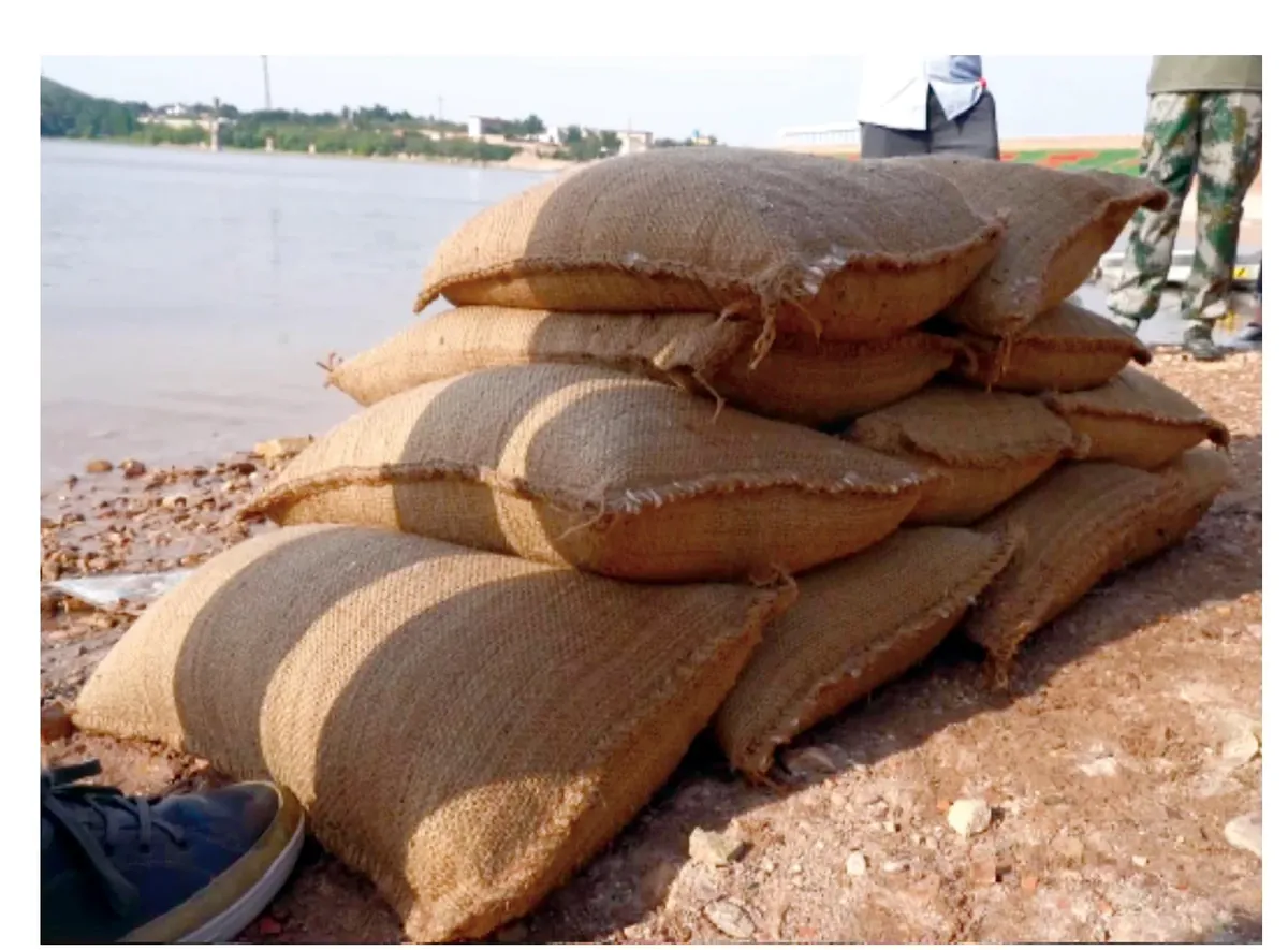 Expanded water absorbing flood bags stacked beside water