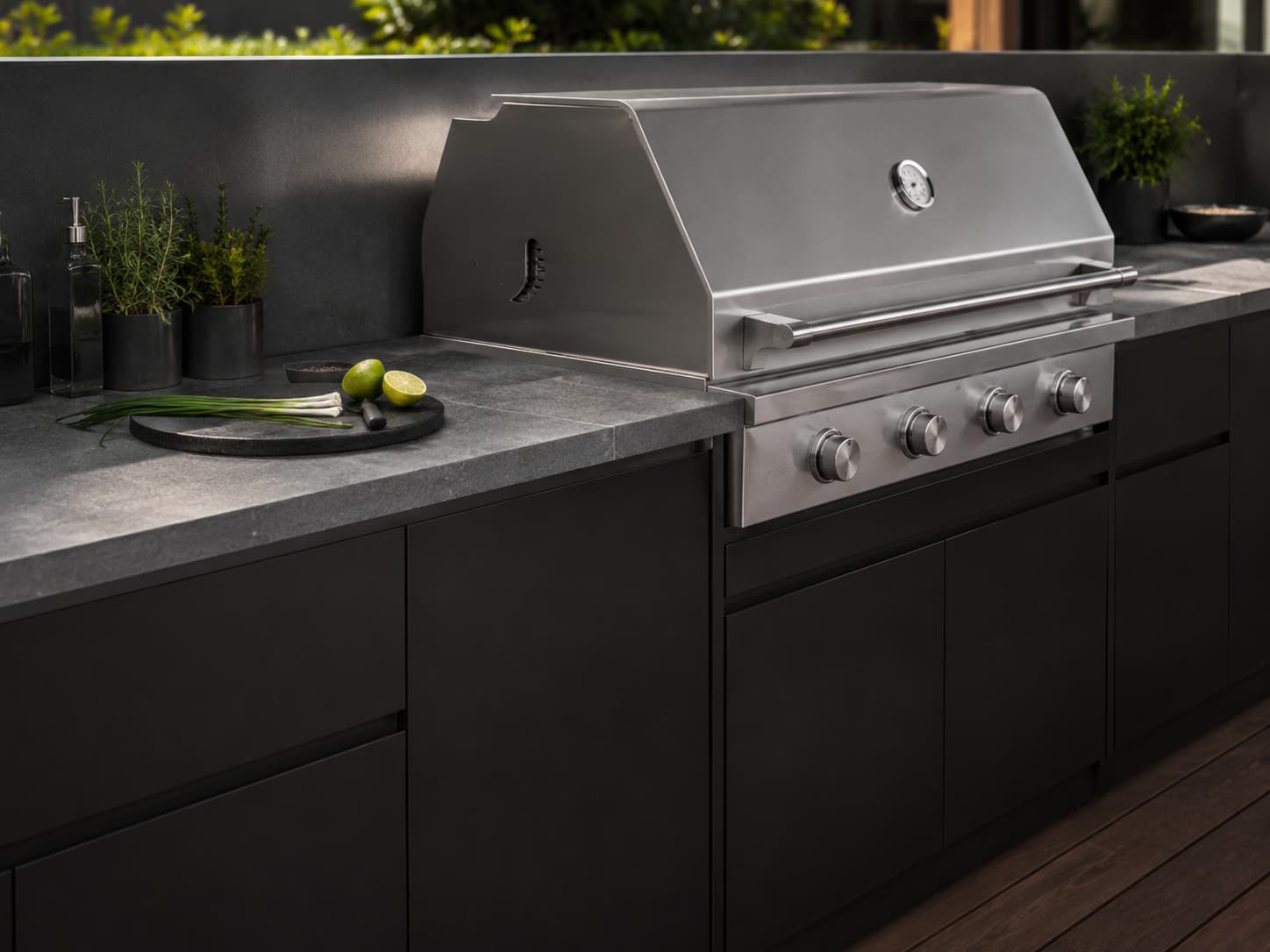 Close view of stainless steel built-in barbecue in black ARVIK outdoor cabinetry