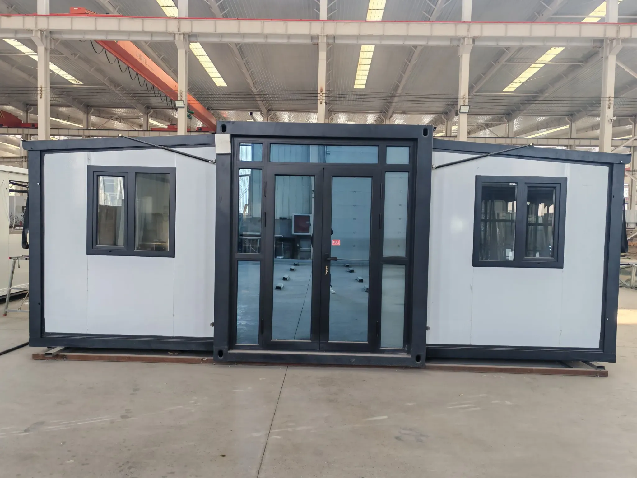 Front elevation of an expandable modular building deployed inside a manufacturing facility