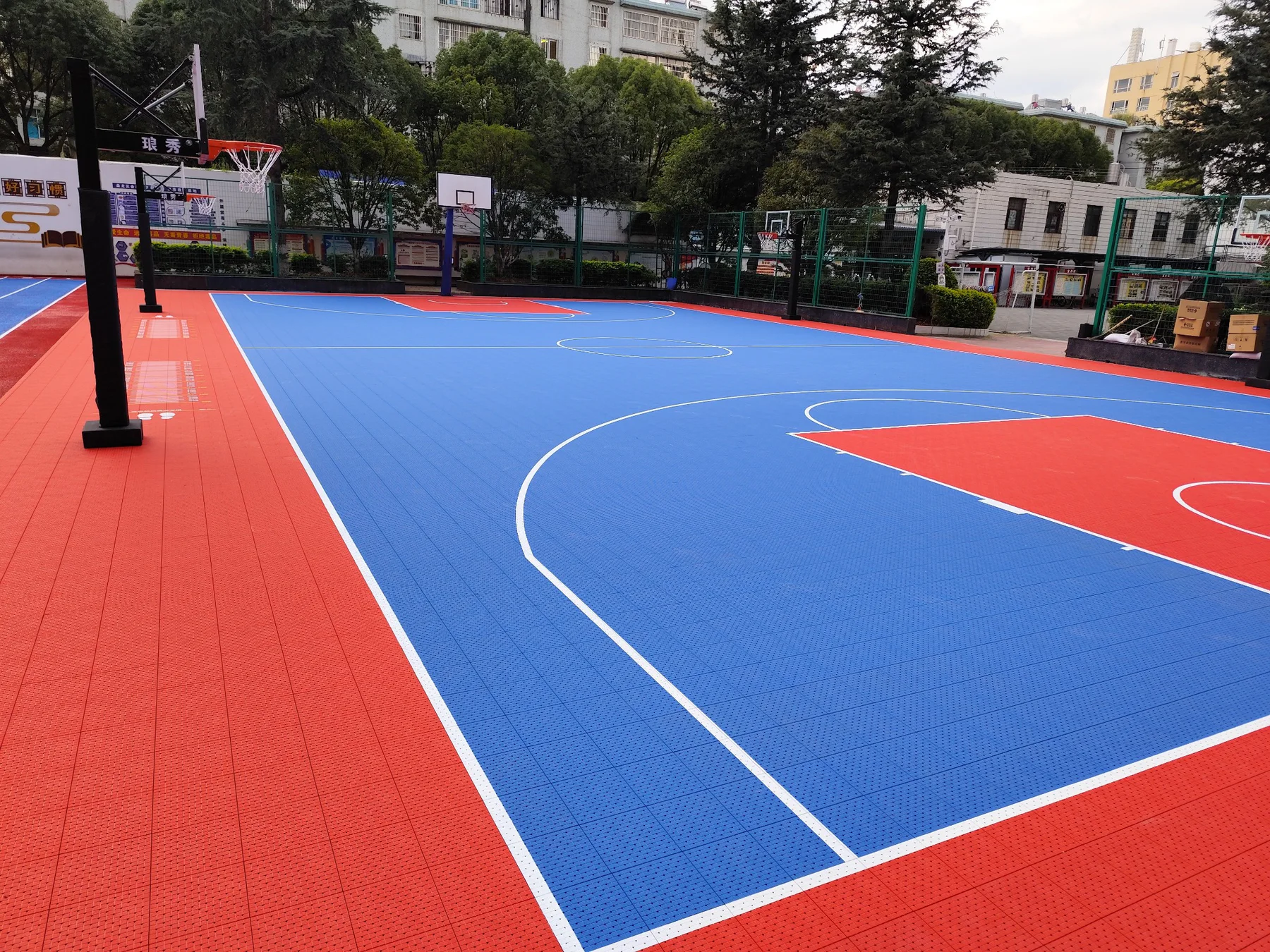 Blue and red outdoor modular basketball court installation