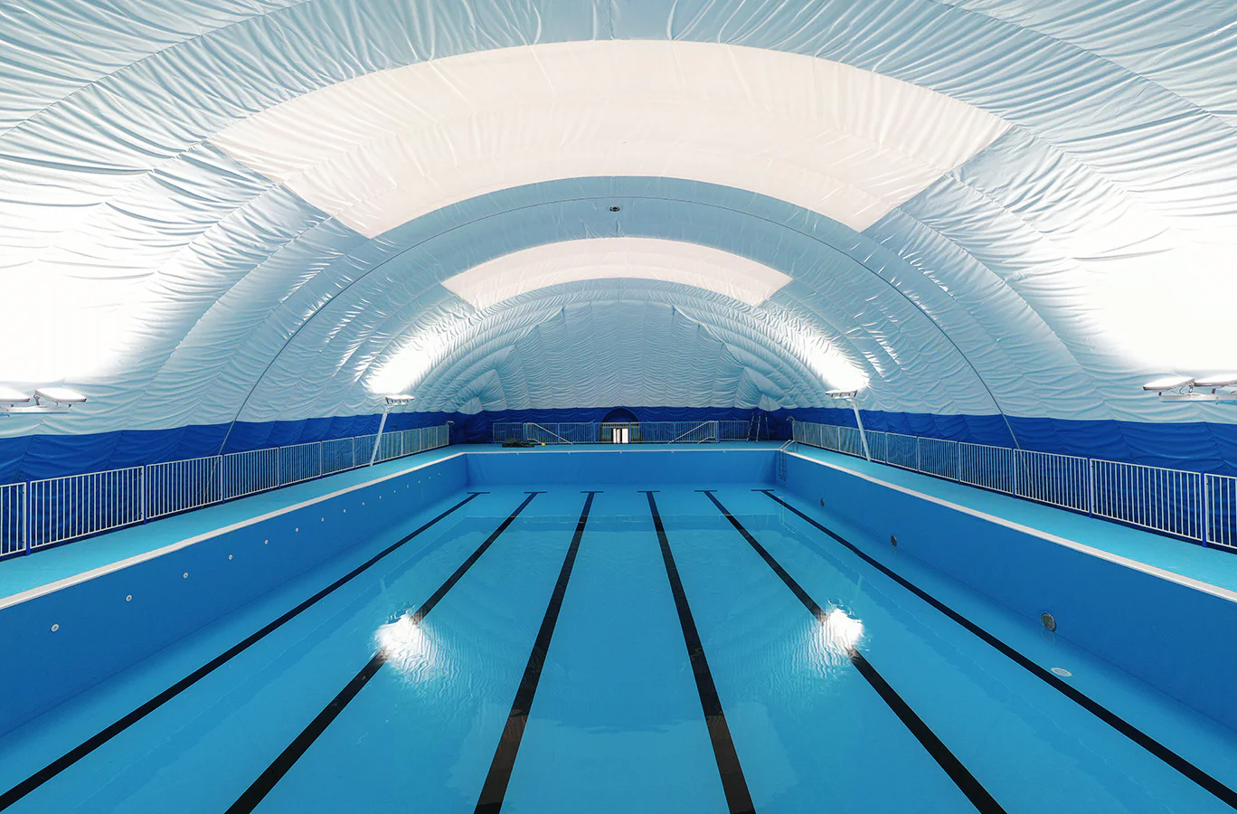 Empty swimming pool inside a bright clear-span air-supported structure