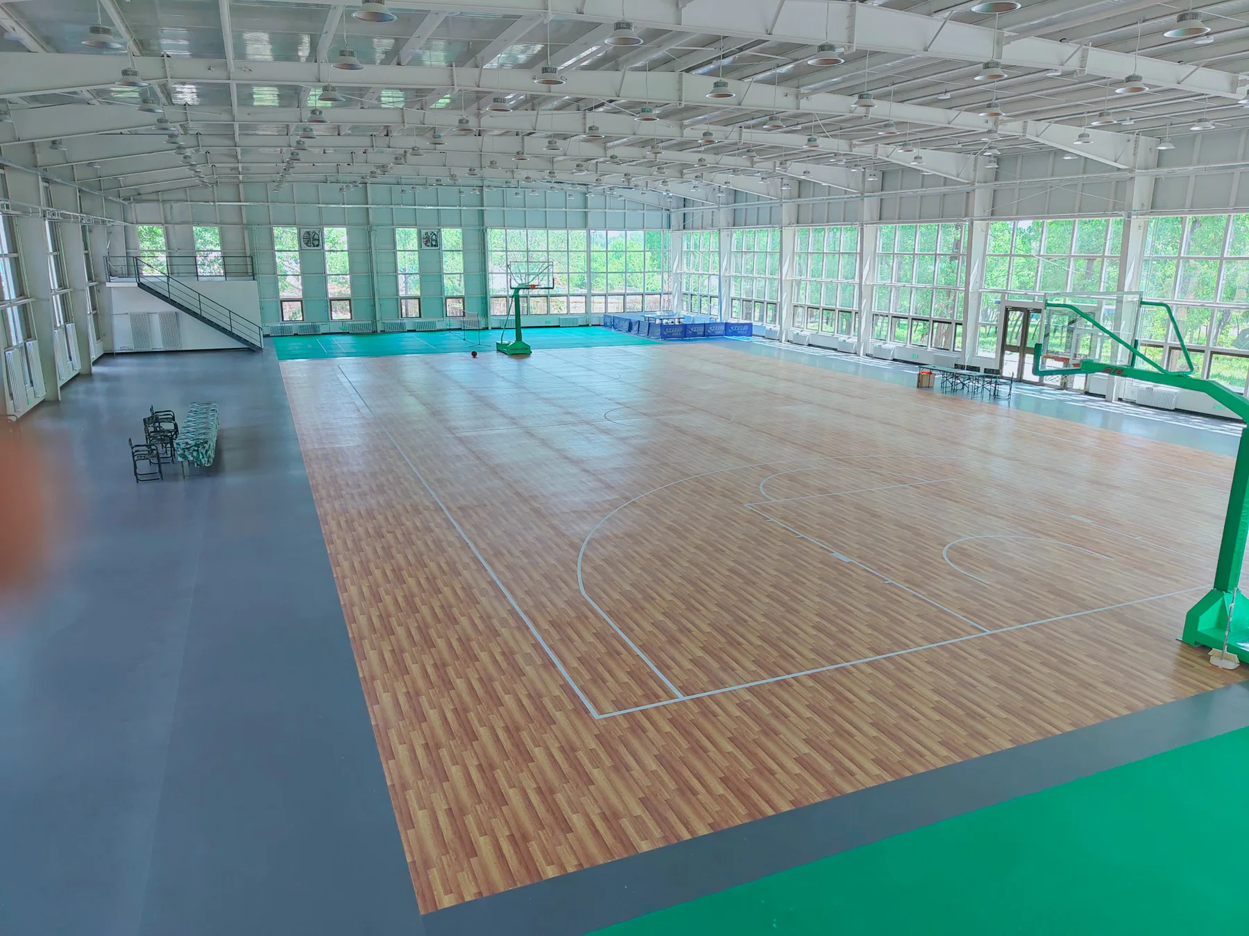 Indoor basketball court with wood-pattern floor and blue painted key