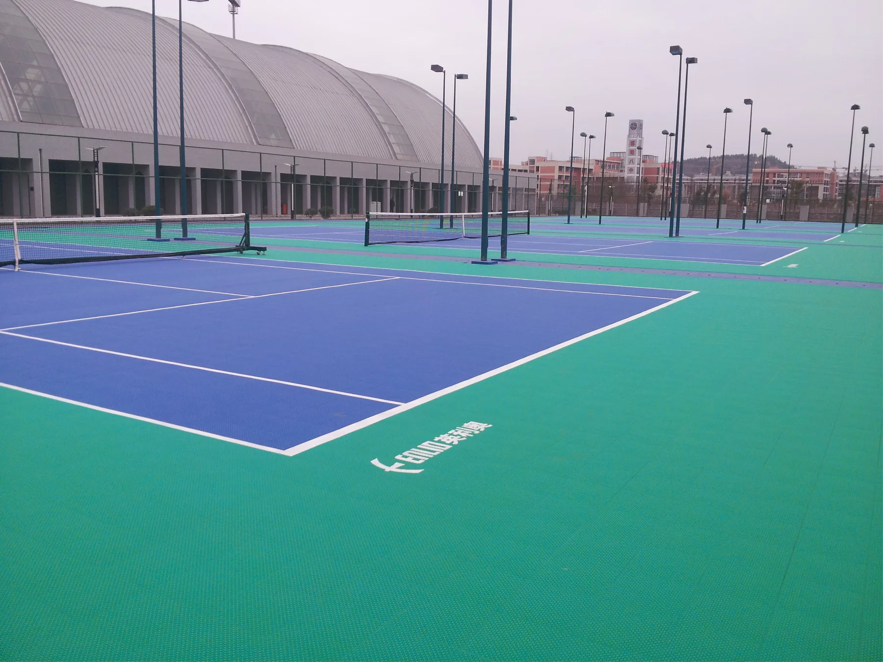 Large blue and green modular tennis-court installation