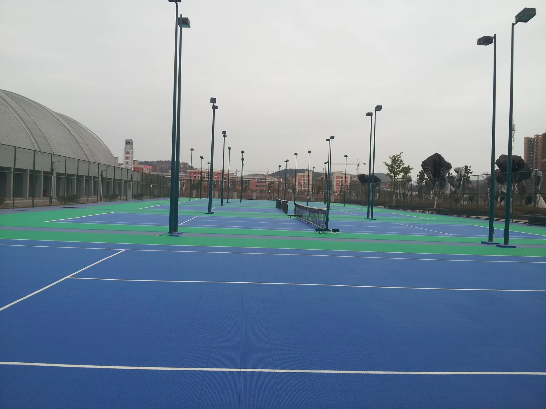 Multi-court blue and green outdoor tennis complex