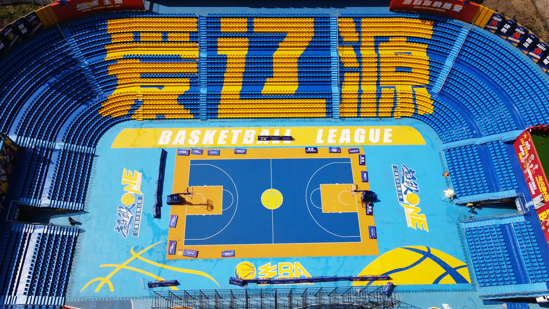 Aerial view of a large Enlio basketball venue with a blue and yellow court
