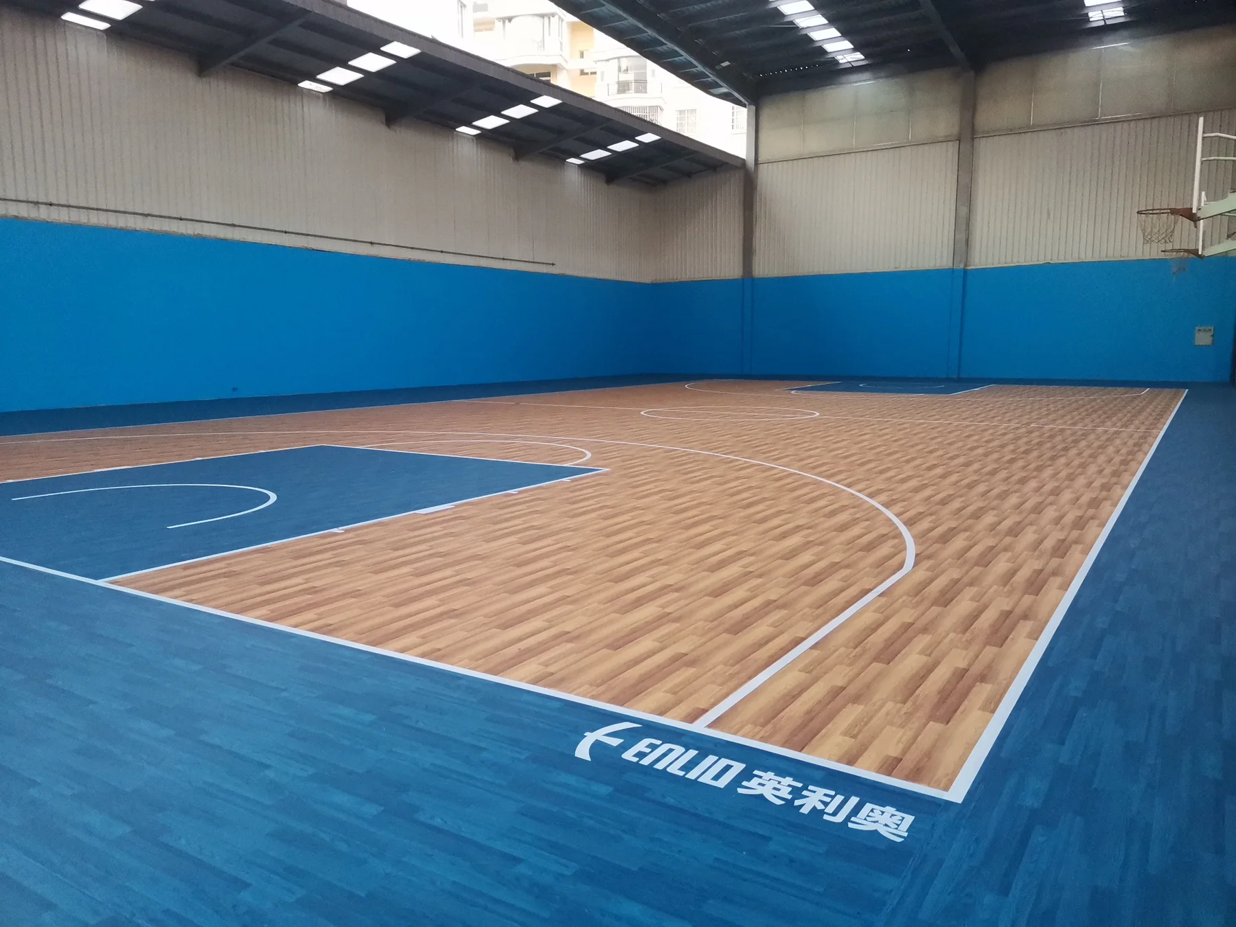 Bright indoor sports centre with wood-pattern basketball floor