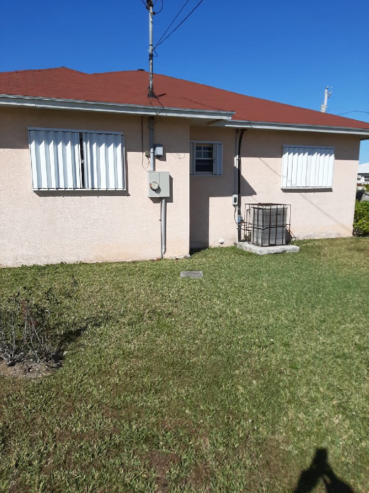 Bahamas residential building with aluminium accordion hurricane shutters closed over exterior windows